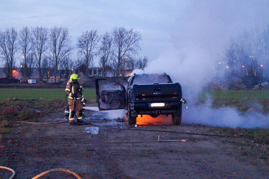 Pickup truck in brand op bouwterrein in Maassluis