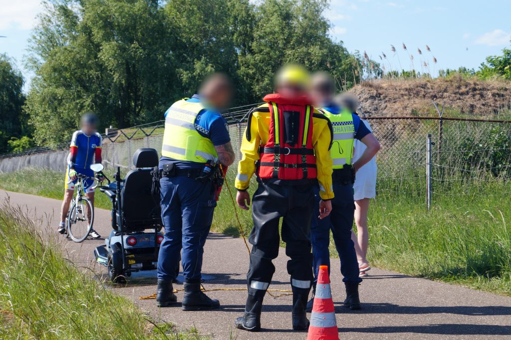 Man met scootmobiel te water aan Koning Willem-Alexander Boulevard in Maassluis